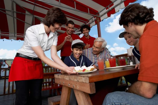 Boy celebrating his birthday with his family in a restaurant