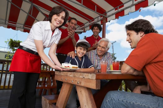 Boy celebrating his birthday with his father and grandfather in a restaurant