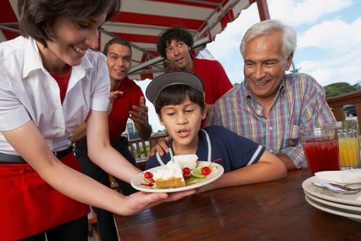 Boy celebrating his birthday with his grandfather in a restaurant