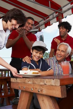 Portrait of a senior man celebrating his grandson's birthday in a restaurant