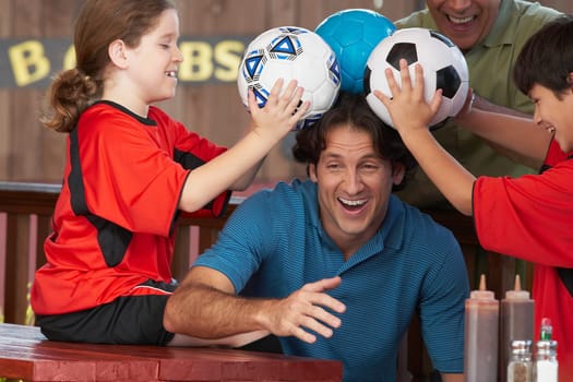 Mid adult man playing with his family in a restaurant