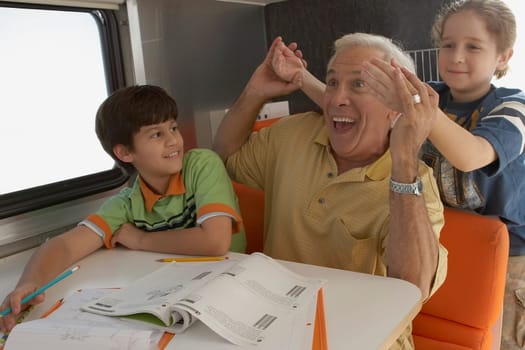 Senior man holding hands of his granddaughter and smiling