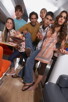 Teenage boy struggling his way through a group of people in a motor home