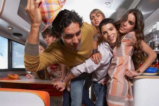 Teenage boy struggling his way through a group of people in a motor home