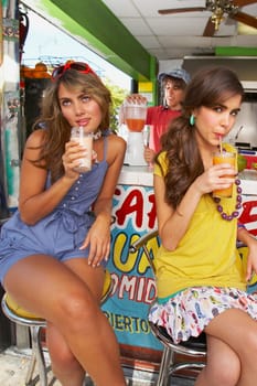 Close-up of a teenage girl drinking juice with her friends