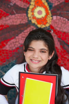 Portrait of a cheerleader holding books and smiling