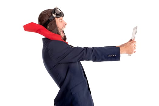Businessman with pilot goggles and tablet isolated in white