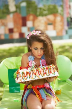 Close-up of a girl blowing out candles on a birthday cake