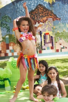 Girl dancing on a table at a birthday party with her four friends beside her