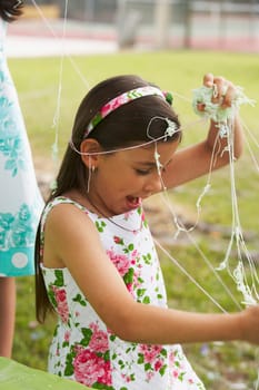 Close-up of a girl playing with party string