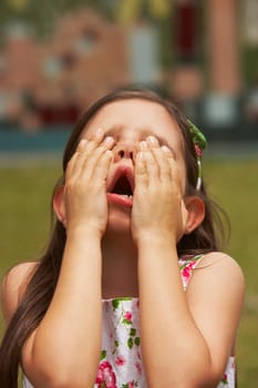 Close-up of a girl with her hand covering her eyes