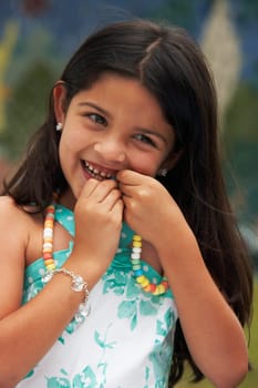 Close-up of a girl eating a candy necklace