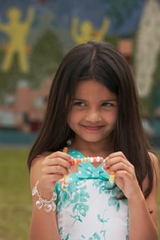 Close-up of a girl holding a candy necklace