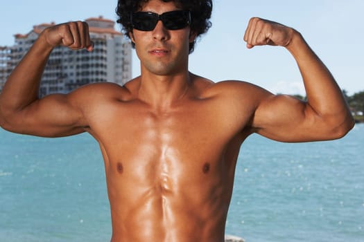 Close-up of a young man flexing his muscles