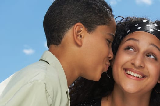 Side profile of a boy kissing a teenage girl