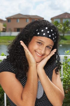 Portrait of a teenage girl smiling with her hands on her chin