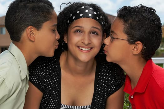 Side profile of two boys kissing a teenage girl