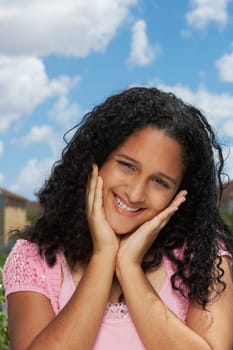 Portrait of a teenage girl smiling with her hands on her chin
