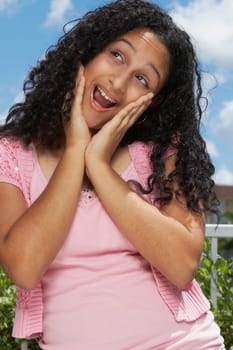 Close-up of a teenage girl smiling with her hands on her chin