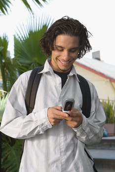 College student using a mobile phone and smiling