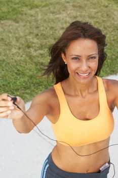 Portrait of a mature woman offering her ear bud and smiling, South Beach, Miami Beach, Florida, USA