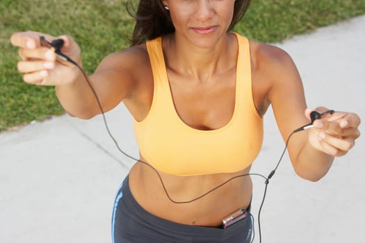 High angle view of a mature woman offering her ear bud, Miami Beach, Florida, USA