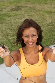 Portrait of a mature woman offering her ear bud and smiling, South Beach, Miami Beach, Florida, USA