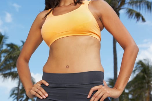 Mid section view of a woman standing with arms akimbo