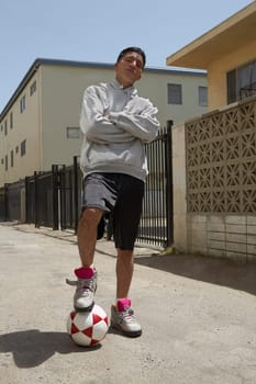 Portrait of a young man standing on the street with his arms crossed