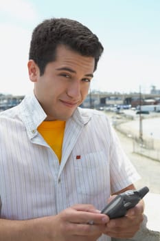 Portrait of a young man using a personal data assistant