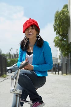 Portrait of a young woman sitting on a bicycle and smiling