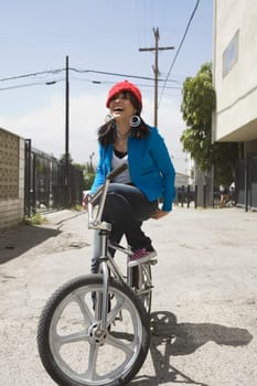 Young woman sitting on a bicycle and laughing