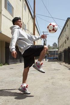 Side profile of a young man playing with a soccer ball