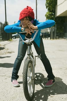 Young woman sitting on a bicycle and talking on a mobile phone