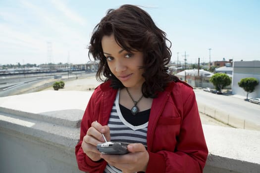 Portrait of a young woman using a personal data assistant