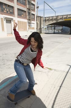 Young woman skateboarding at a roadside