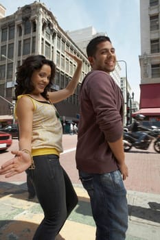 Side profile of a young couple reggaeton dancing on the road
