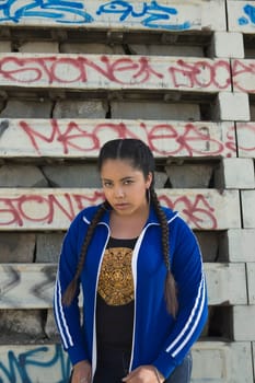 Portrait of a young woman standing in front of a wall