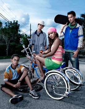 Portrait of a young woman on a low rider bicycle with her three friends beside her
