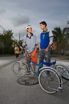 Two teenage boys standing behind a low rider bicycle