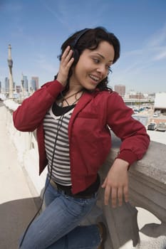Close-up of a young woman listening to music and smiling