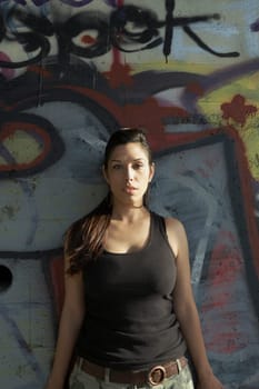 Portrait of a young woman leaning against a wall