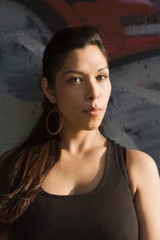 Portrait of a young woman leaning against a wall