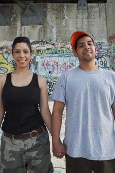 Portrait of a young couple holding each other's hand and smiling