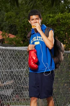 Teenage boy listening an ipod and eating empanada