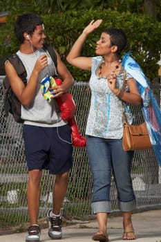 Teenage boy and his sister looking at each other and walking on the walkway