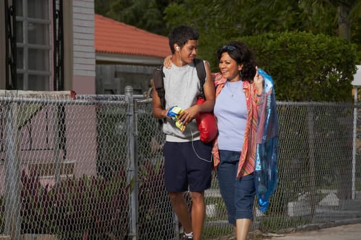 Mature woman and her son walking on the walkway