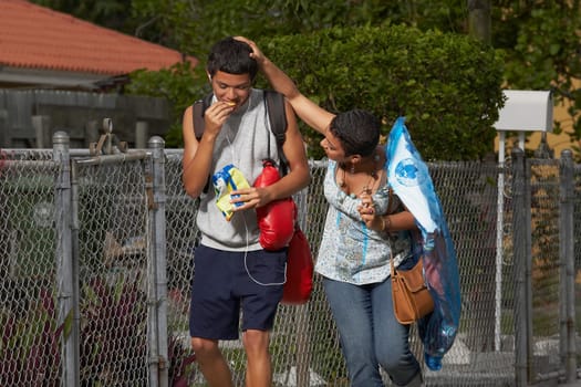 Young woman walking beside his brother and touching his head