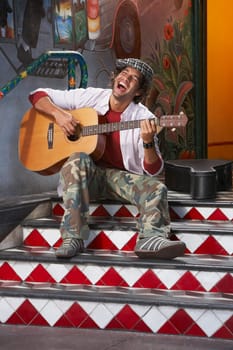 Young man playing a guitar and singing