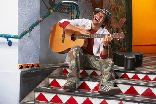 Young man playing a guitar and singing